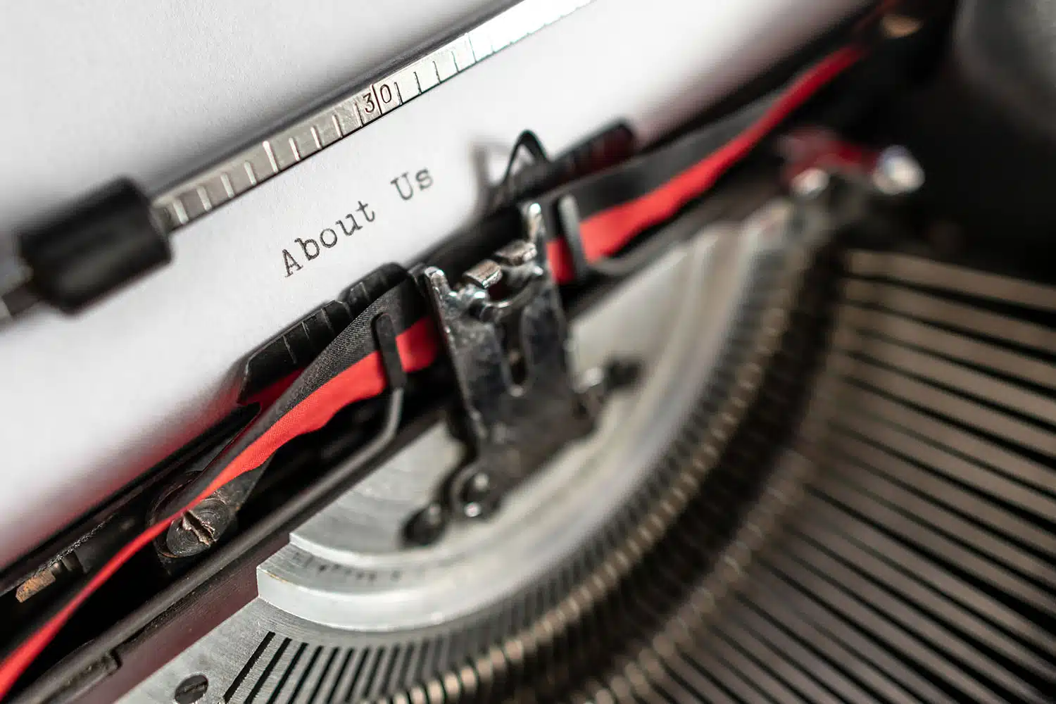Classic typewriter spelling out "About Us"